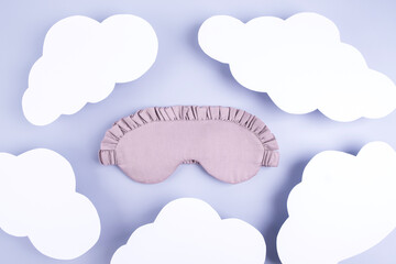 Sleep mask on paper background with  paper clouds. Healthy night , travel, and fly minimalism concept