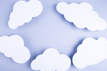 Obraz premium Blue background with frame made of paper white clouds