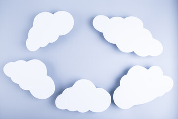 Blue background with frame made of paper white clouds