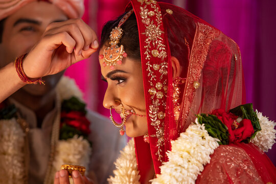 Couple performing Sindoor Daan ritual during their wedding