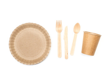 Set de plato, vaso y cubiertos de cartón papel marrón sobre fondo blanco liso y aislado. Vista superior y de cerca. Copy space