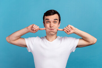 Photo of young guy have fun pouted cheeks fool childish stupid hold breath isolated over blue color...