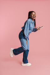 Young black woman laughing and using mobile phone
