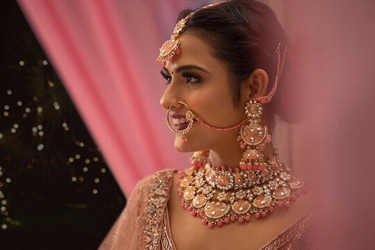 Portrait of beautiful smiling Indian bride in traditional wedding clothing and jewellery