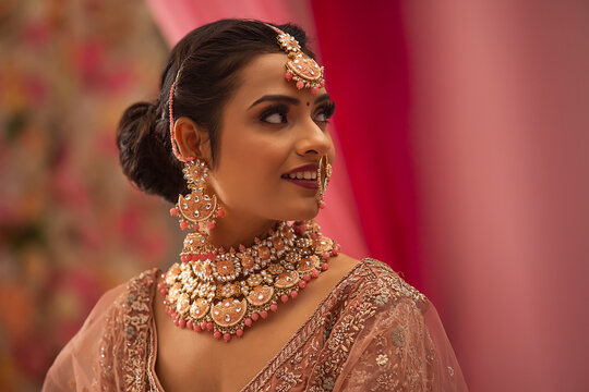 Portrait of beautiful smiling Indian bride in traditional wedding clothing and jewellery