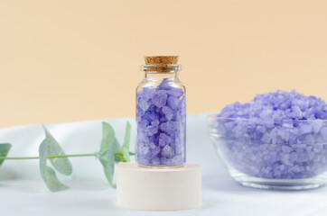 Lavender sea salt in a transparent bottle on a round podium