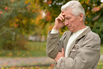 portrait of sad senior man in park