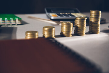 piles of coins with calculator on table