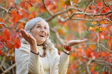 Portrait of happy senior woman in autumn park