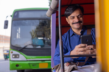 Man using Smartphone while going to office by Auto Rickshaw