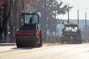 Close view on the asphalting machines. The big roller aligns asphalt for the new road