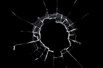 A hole from a shot in the window. Cracked texture isolated on black background. - obrazy, fototapety, plakaty