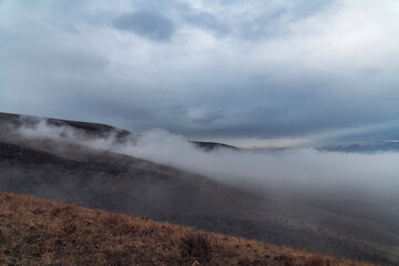 Beautiful winter landscape. The huge clouds above the mountains. Foggy weather