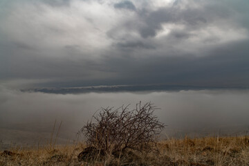 Beautiful winter landscape. The huge clouds above the mountains. Foggy weather