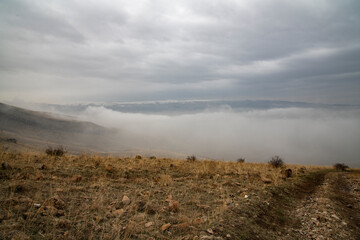 Beautiful winter landscape. The huge clouds above the mountains. Foggy weather