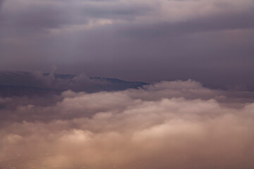 Naklejka na ściany i meble Beautiful winter landscape. The huge clouds above the mountains. Foggy weather