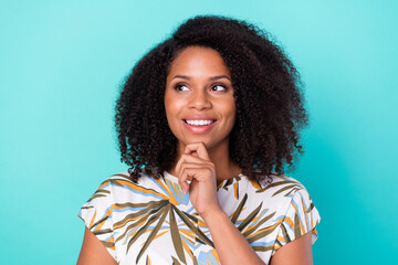 Photo of pretty dreamy dark skin lady wear print t-shirt arm chin looking empty space smiling isolated turquoise color background