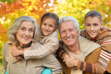 Grandparents with grandchildren posing outdoors in autumn