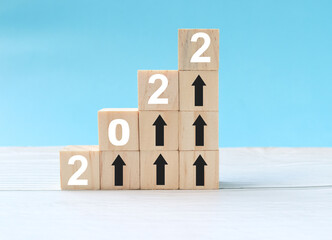 2022 Developing a Successful Business and a Growing Growth Idea with an upward-pointing arrow on a wooden block is a growing graph.