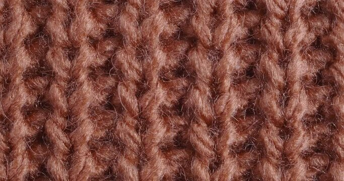 The texture of the knitted part is close-up. Macro fragment. Terracotta background.