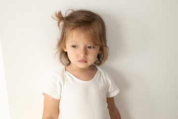 Closeup portrait of beautiful blonde Caucasian little girl. Sad