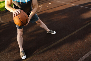 White man playing basketball while working out on sports ground