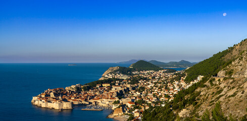 Fototapeta na wymiar view of the historic city of Dubrovnik and the Adriatic Sea at sunrise with a full moon in the sky