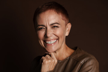 Obraz premium Senior ginger woman with short hair laughing and looking at camera