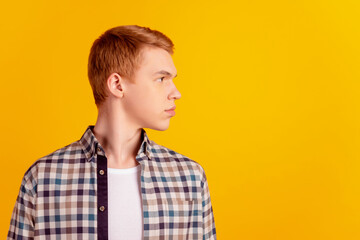 Profile side photo of young handsome man look empty space focused isolated over yellow color background