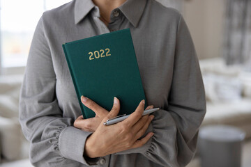 Close Up Of Woman Holding New Year 2022 Diary At Home