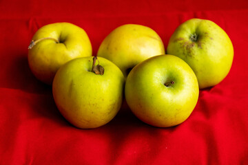 green apples close up on red background