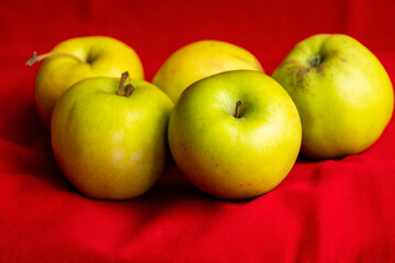 green apples close up on red background