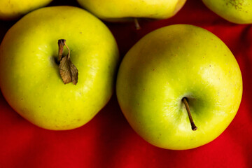 green apples close up on red background