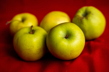 green apples close up on red background