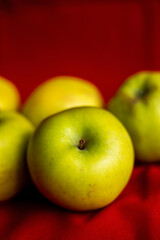 green apples close up on red background