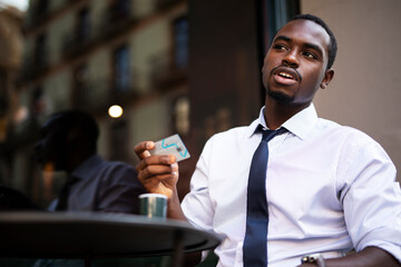 Businessman in cafe holding a credit card. Guy making online payment. Man paying the bill in cafe with a credit card.