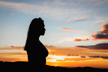 retrato de una  mujer latina en un hermoso atardecer  con anteojos en su cabeza