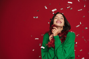 White woman laughing while posing with Christmas tinsel garland