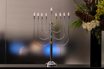 Menorah lampada tradizionale della cultura ebraica su tavolo con fiori
