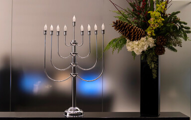 Menorah lampada tradizionale della cultura ebraica su tavolo con fiori