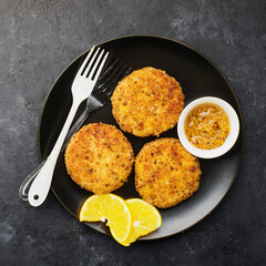 Cod fish potato cakes served with lemon and honey mustard. Top view.