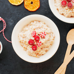 Christmas food. Festive New Year's feed. Oatmeal with caramel orange and red and white sweets. Top view.