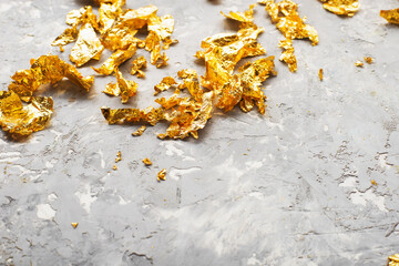 Luxurious golden background. Gold patal, precious flakes. The colors of the year are yellow gray,