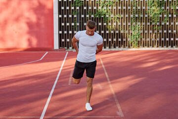 Obraz premium man in white t-shirt on the sports ground workout motivation