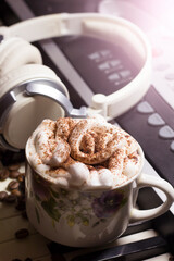 A cup of cappuccino and headphones, music