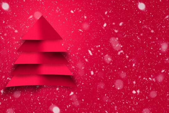 Design of red christmas tree with paper texture and snowy background. Christmas concept for advertising.
