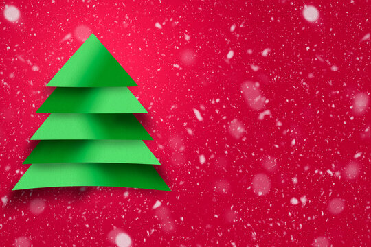 Design of green christmas tree with paper texture and snowy background. Christmas concept for advertising.