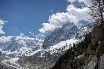 Obraz premium A view of the mountain peaks and clouds at the Mer de Glace in Chamonix, France on a sunny summer day in the French Alps