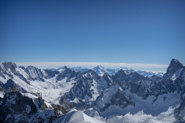 Fototapeta premium A view of the French Alps, Swiss Alps, and Italian Alps on a sunny summer day from the Aiguille du Midi near Mont Blanc in Chamonix, France