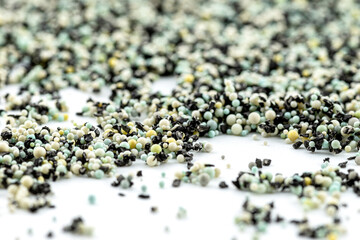 A background made out of strewn inside an activated carbon filter and water filter balls, isolated on a white background, selective focus in the center.